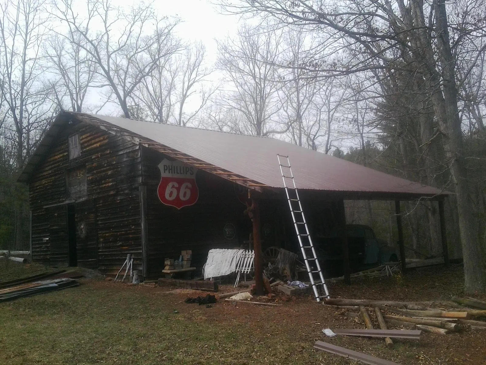 New metal roof on an open sided timber barn with a vintage sign in Lynn Center