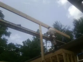 Carpenter setting a ridge beam over a new addition frame — Ice Dam Removal by Roofing Brothers in Lynn Center