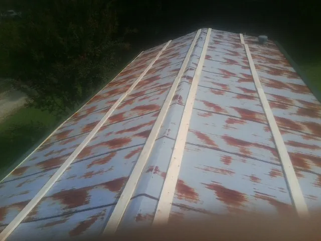 Rusted metal roof panels with new wood purlins before replacement — Storm Damage Roof Repair in Lynn Center by Roofing Brothers