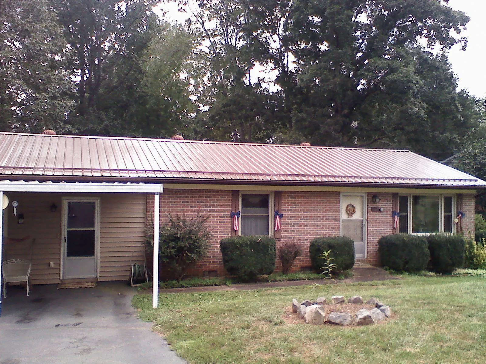 Bronze metal roof and carport on a brick ranch home — Roof Repair work by our crew in Lynn Center
